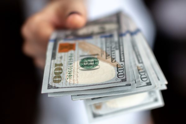 Close up female hand Counting and holding money us dollar.